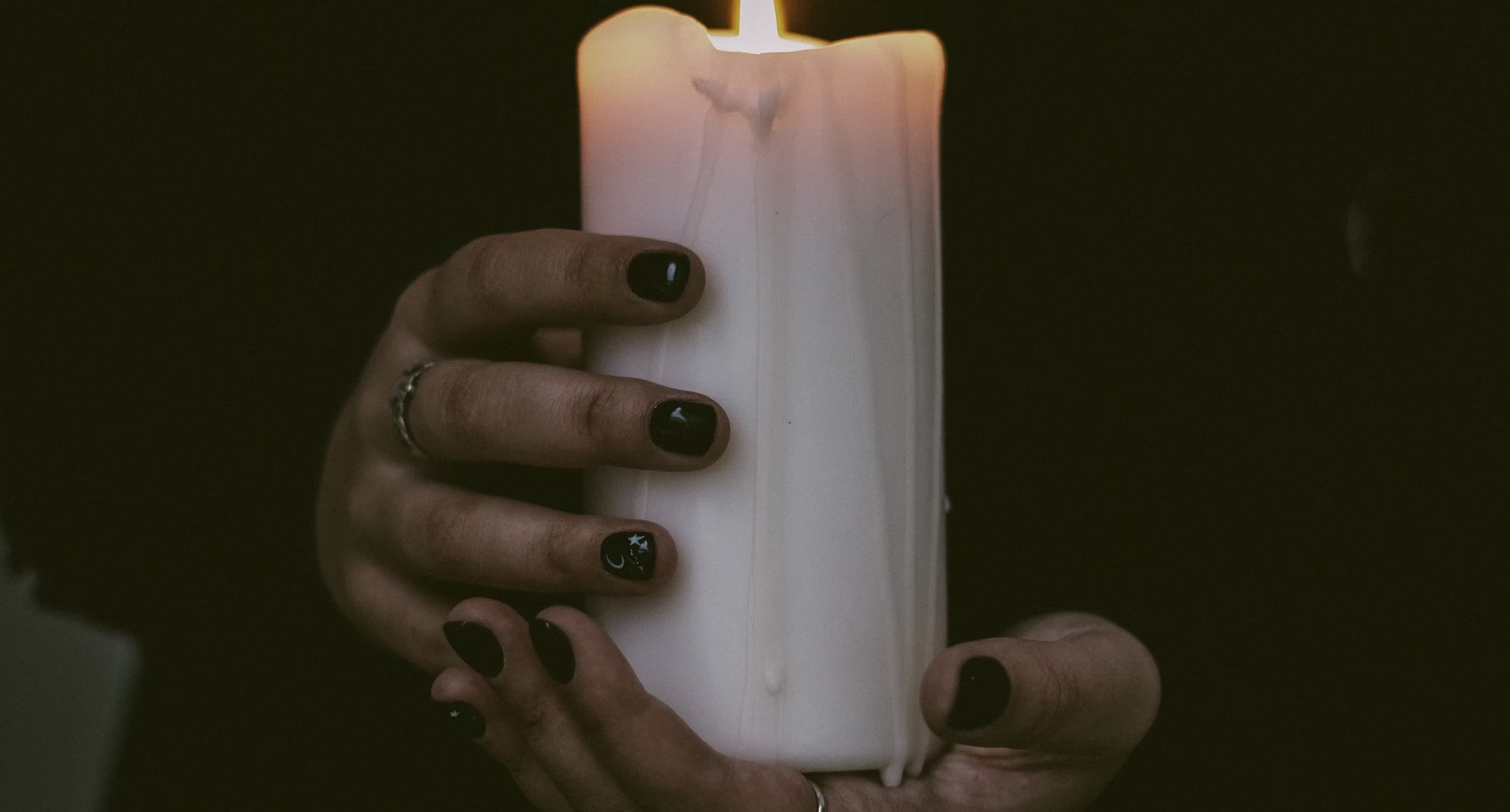 Hands cupped around candlelight