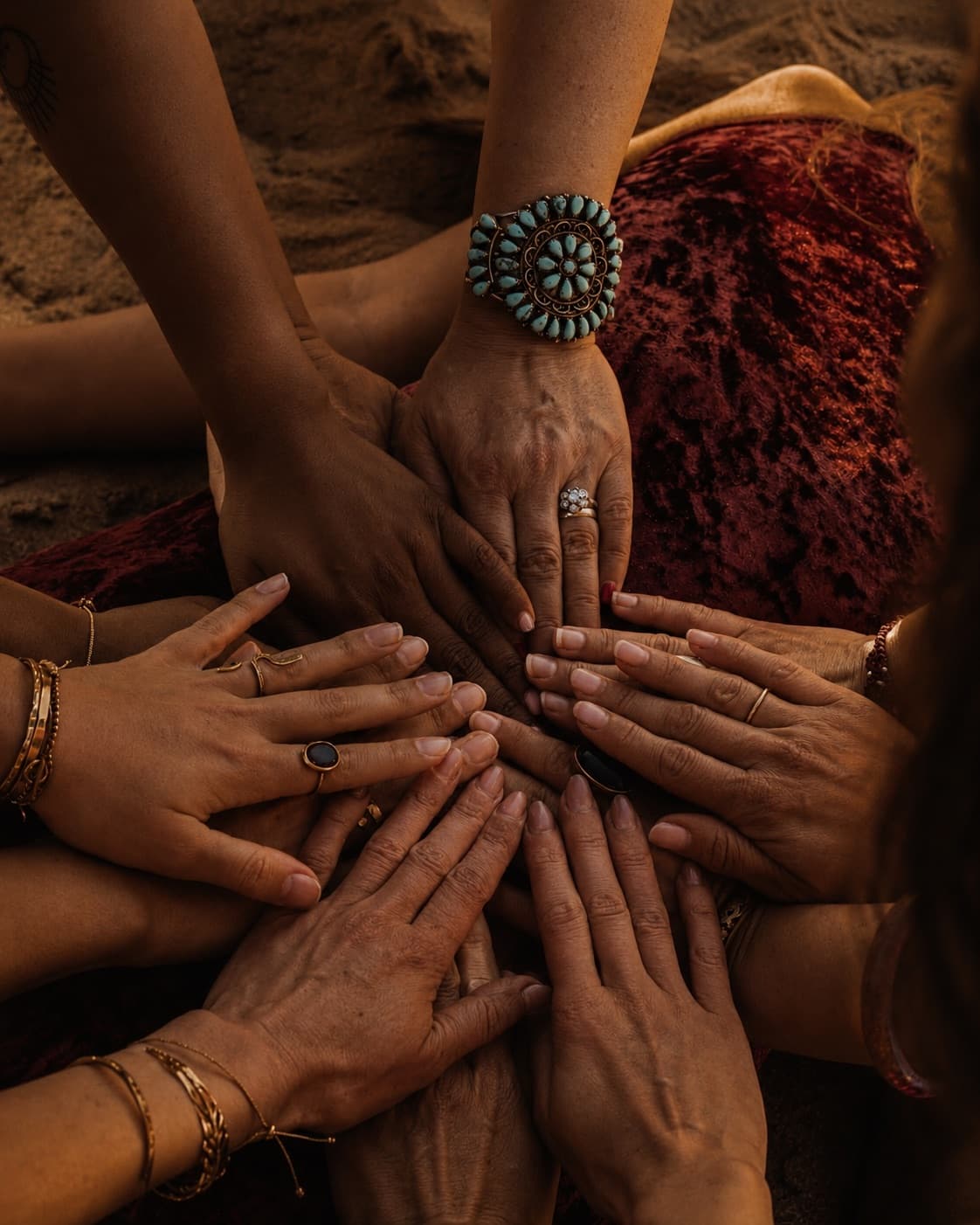 The hands of many women resting together in a circle