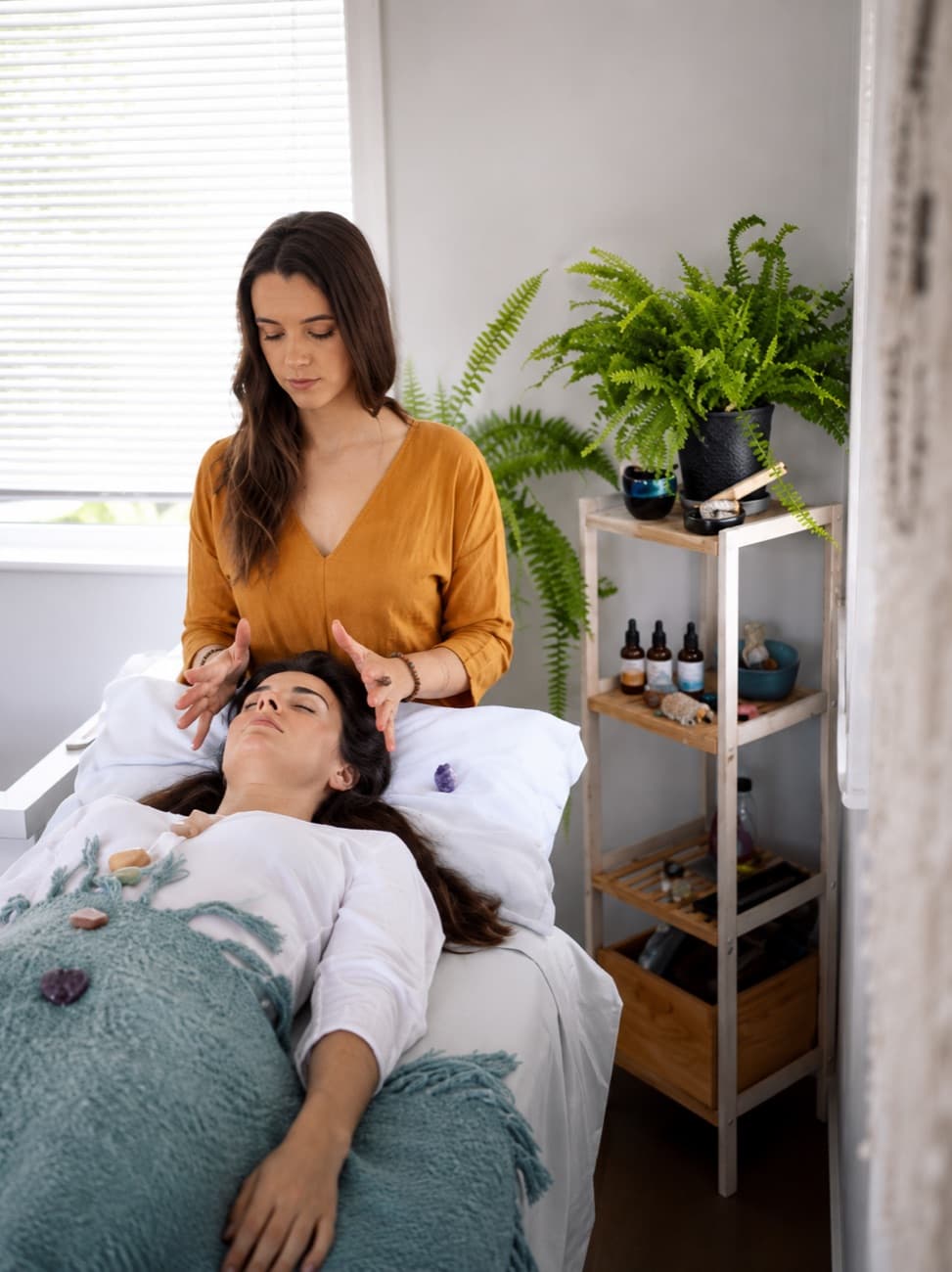 A Reiki healing session, hands held gently above a client resting in the healing room