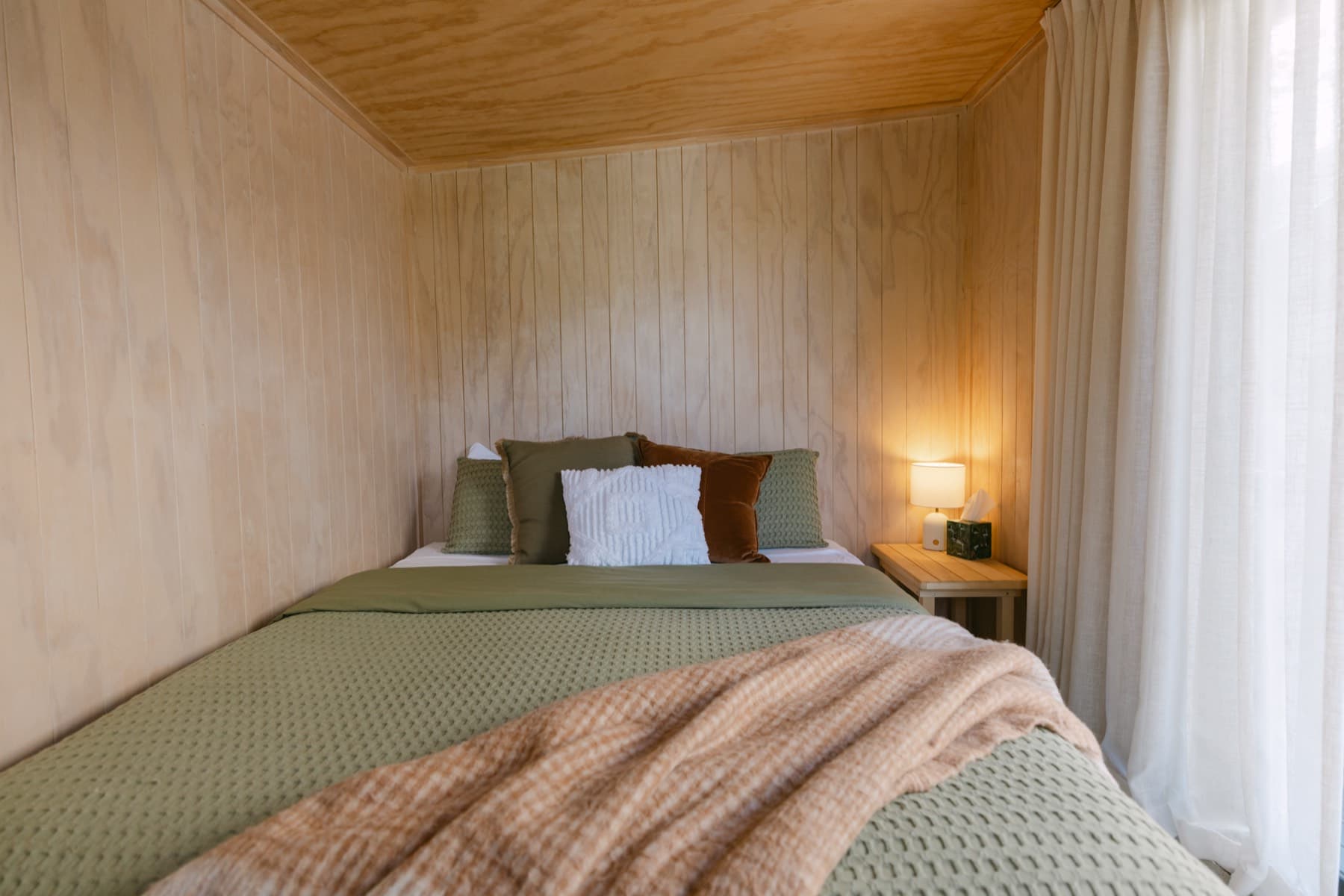 The Hauora Cabin at Kula Muriwai, a standalone cabin with a king bed