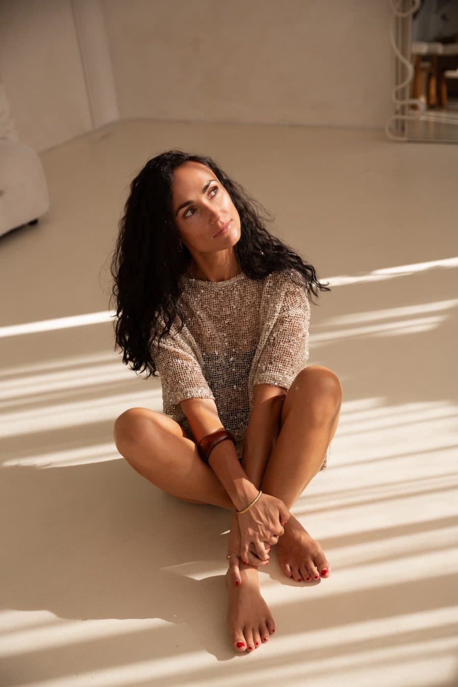 Sofire Harris seated on the floor in warm afternoon light, looking towards the window