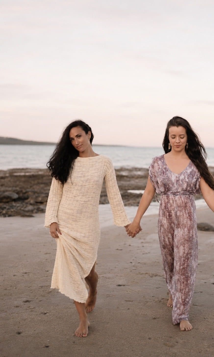 Sophia Cataldo and Sofire Harris walking hand in hand along the shoreline at dusk
